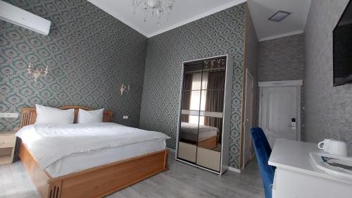 ein Schlafzimmer mit einem Bett, einem Tisch und einem Spiegel in der Unterkunft Siena Hotel in Odessa
