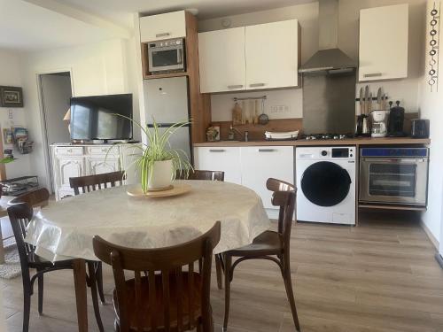 a kitchen with a table and chairs in a kitchen at Perle de vue in Glaine-Montaigut