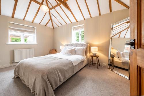 a bedroom with a large bed and a chair at The Cottage at Tuffon Hall in Sible Hedingham