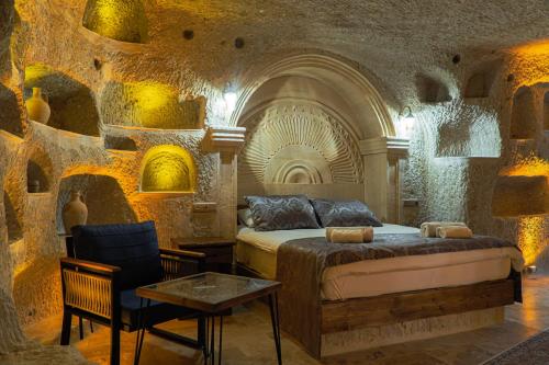 a bedroom with a bed and a table and a chair at Tyana Cave House in Nar