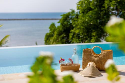 a table with a basket and a bottle and a purse at Hortensia Luxury Beach Villa in Chaloklum