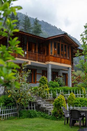 a large wooden house with a balcony on top at 8fold by Larisa, Jibhi in Jibhi