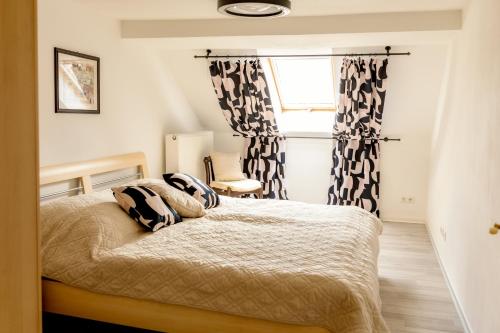 a bedroom with a bed with black and white curtains at Ferienwohnung Otto in Pegnitz
