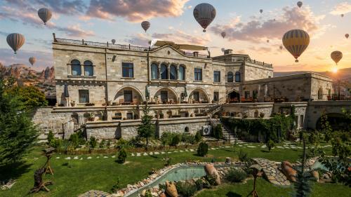 a group of hot air balloons flying over a building at Goreme Inn Hotel Only Adult in Göreme