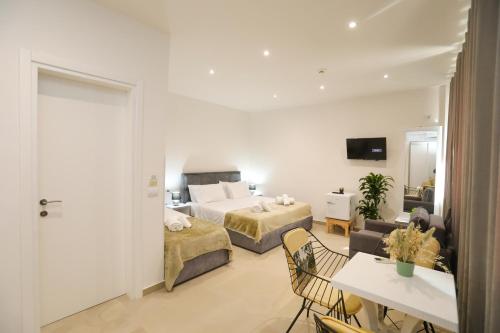 a bedroom with two beds and a living room at Hotel SUNSET GL in Vlorë