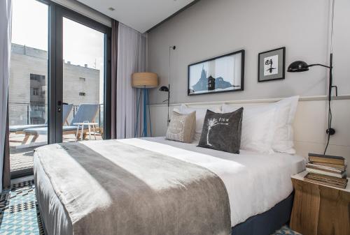 a bedroom with a large bed and a balcony at Bezalel Hotel - an Atlas Boutique Hotel in Jerusalem