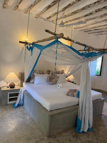 a bedroom with a bed with a canopy at Coastal calm apartment in Watamu