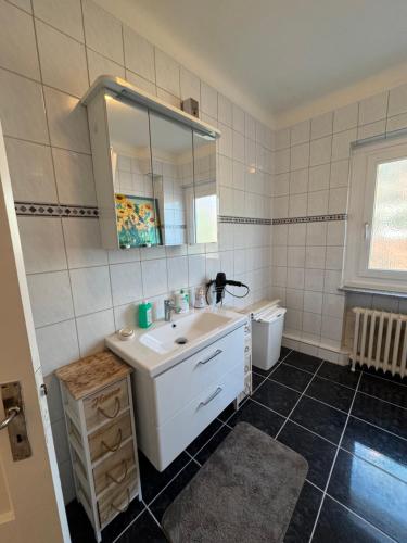 a bathroom with a sink and a mirror and a toilet at City Quartier Wedel in Wedel