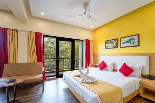 a hotel room with a bed and a window at Rosetum Anjuna Goa in Anjuna