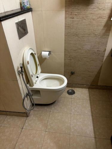 a bathroom with a toilet with the seat up at VR Residency 83 in Gurgaon