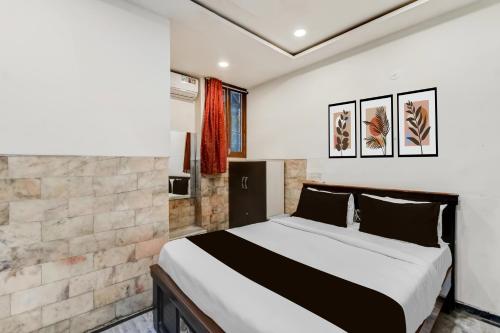 a bedroom with a bed and a brick wall at Super Hotel O MG Road Raniganj Formerly Holiday Hotel in Hyderabad