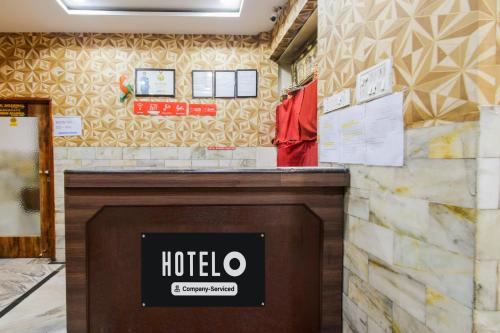 a hotel counter with a sign on a wall at Super Hotel O MG Road Raniganj Formerly Holiday Hotel in Hyderabad