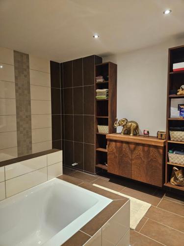 a large bathroom with a tub and a book shelf at Die Haas-Villa in Berg
