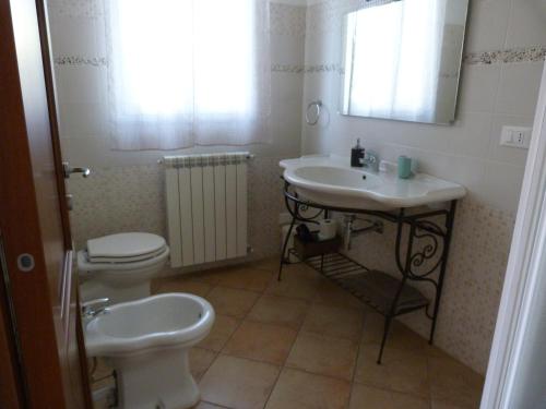 a bathroom with a toilet and a sink at La Testa Fra Le Nuvole in Finale Ligure