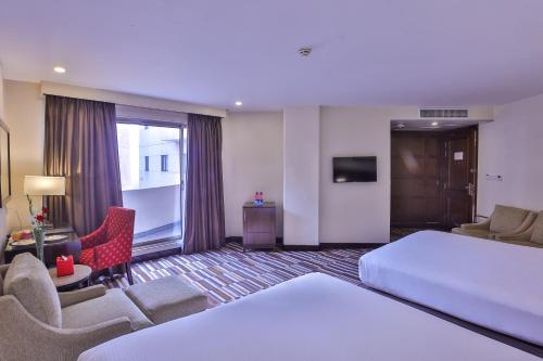 a hotel room with a bed and a living room at Avari Xpress Gulberg in Lahore