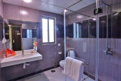 a bathroom with a toilet and a sink and a shower at Avari Xpress Gulberg in Lahore
