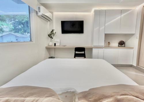 a bedroom with a white bed and a window at Reset (Hotel-Cafe-Coworking) in Cali
