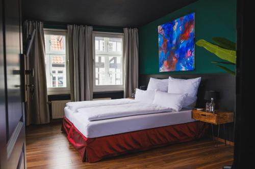 a bedroom with a bed with a painting on the wall at friedrich DAS BETT in Braunschweig