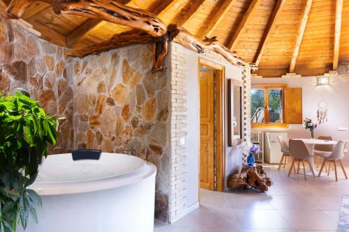 a bath tub in a room with a stone wall at Pinnettu Sa Rosa - Jacuzzi & Relax Deluxe in Quartu SantʼElena