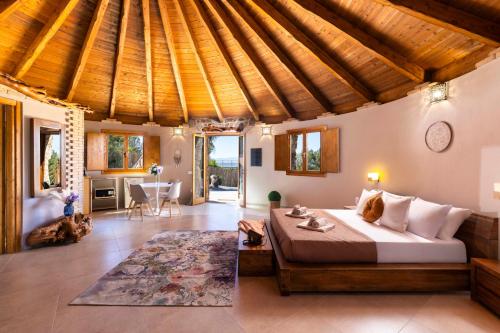 a bedroom with a large bed and a wooden ceiling at Pinnettu Sa Rosa - Jacuzzi & Relax Deluxe in Quartu SantʼElena