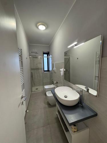 a bathroom with a sink and a toilet and a mirror at Villa Altomare in Otranto