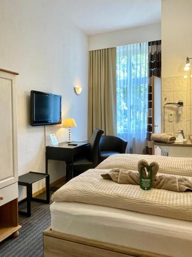 a hotel room with a bed and a desk and a television at Hotel Antoni in Bochum
