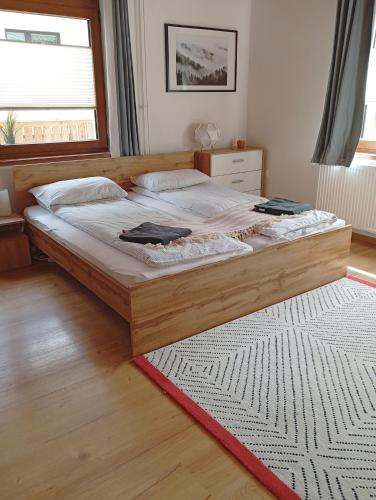a bedroom with a large wooden bed and a window at Apartma Discovering Slovenia in Luče
