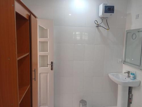 a white bathroom with a sink and a mirror at PrimeAxishub in Ilorin