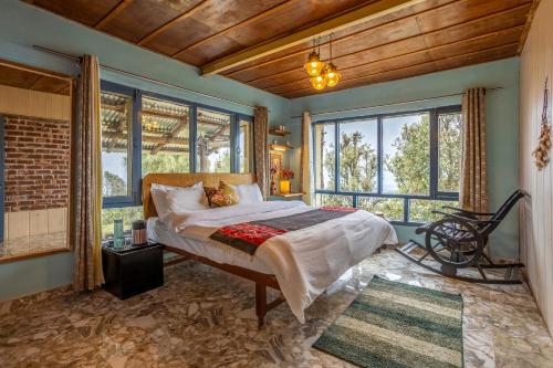 a bedroom with a bed in a room with windows at Vibe Hostel Naddi - Near Dal Lake in Dharamshala