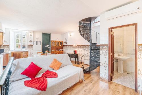 a living room with a white couch with red pillows at Casas da Biquinha in Sintra