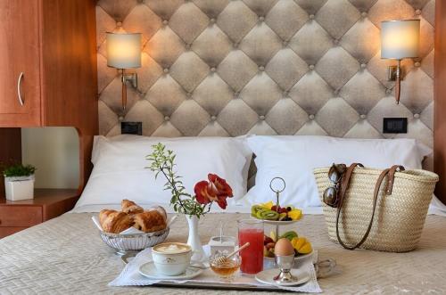 a breakfast tray on a bed with food on it at Hotel Noris in Finale Ligure