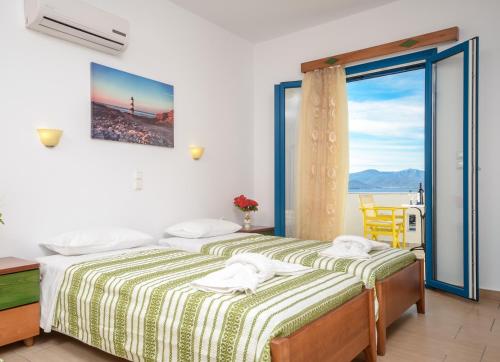 a bedroom with a bed with a view of the ocean at Magic Summer in Agia Anna Naxos