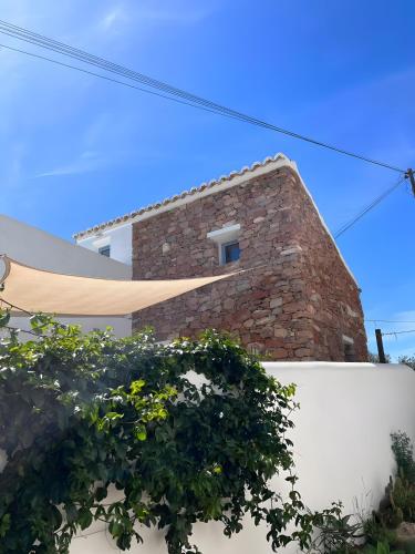 a brick house with a white wall at Casa Osga in Moncarapacho