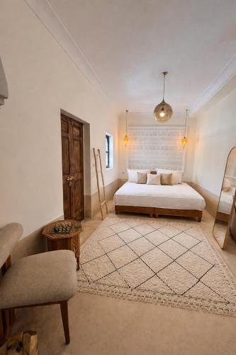 a large bedroom with a bed and a chair at Riad Aura Suites & Spa in Marrakesh