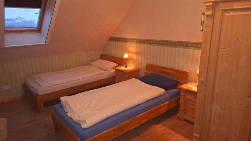 a bedroom with two beds and a window at Darpvenner Diele in Ostercappeln