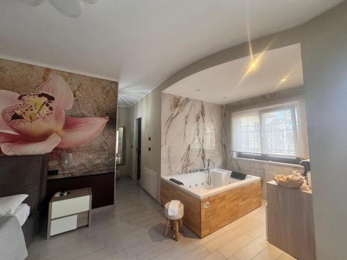 a large bathroom with a tub and a flower mural at B&B Golden House & spa in Rose