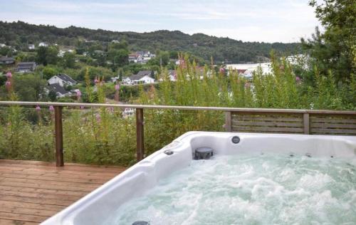 a jacuzzi tub on a deck with a view at Luxury Fjord Cabin with jacuzzi, boat dock & view in Sveio