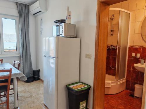 a kitchen with a refrigerator with a microwave on top of it at Apartments Sofija in Slatine