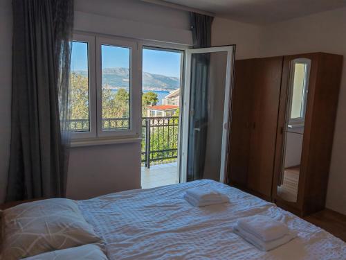 a bedroom with a bed and a large window at Apartments Sofija in Slatine