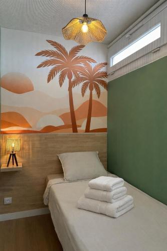 a bedroom with a bed with a painting on the wall at Le Cocon de Milan in Valras-Plage