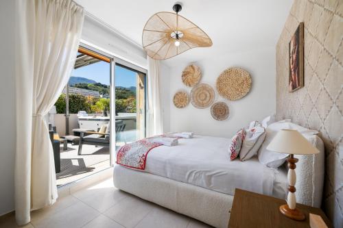 a bedroom with a bed and a view of a patio at Le Coq Elysium - Exceptional 220 sqm Penthouse - Private Terrace & Jacuzzi - AC - 3 Parking Spaces in Menton