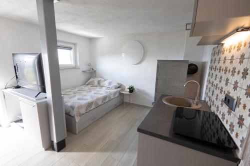 a small bedroom with a bed and a sink at Nogica in Otočec