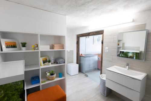 a white bathroom with a sink and a mirror at Nogica in Otočec