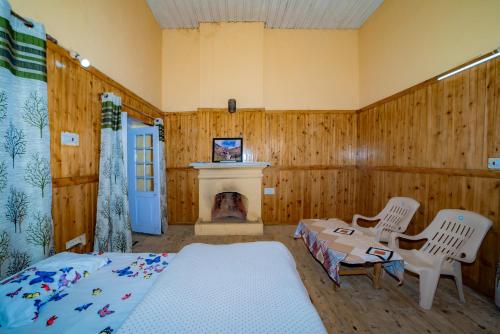 a living room with a bed and a fireplace at Forest Rest House Gahan in Bāgi