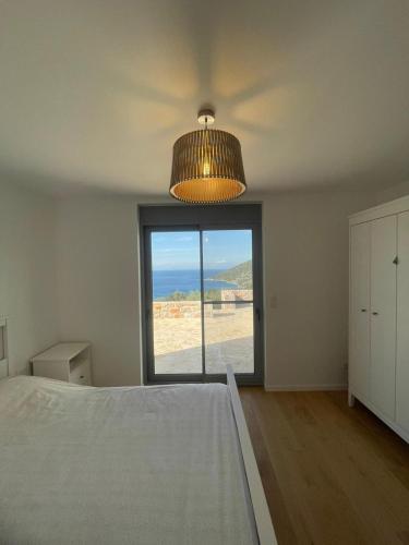a bedroom with a large bed and a large window at Contemporary villa with pool and sea view in Poulithra