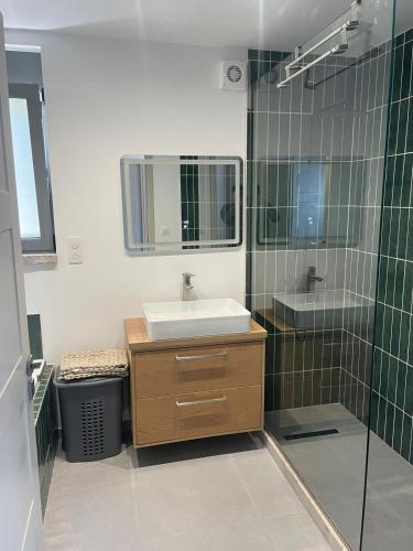 a bathroom with a sink and a shower with a mirror at Contemporary villa with pool and sea view in Poulithra