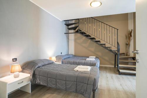 a bedroom with two beds and a staircase at Menaggio Tosca Apartments in Menaggio