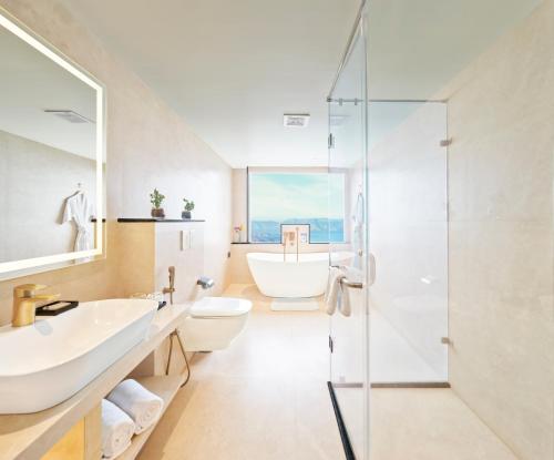 a bathroom with a tub and a sink and a toilet at The Cliff by Zuper - Panchgani in Panchgani