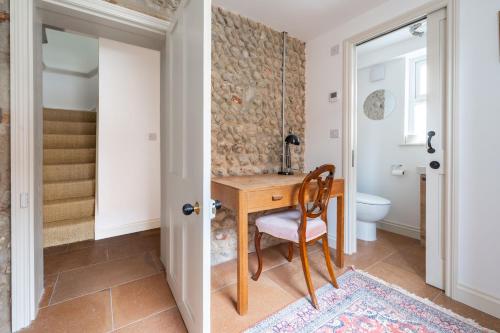 a home office with a wooden desk and a chair at Mollies Cottage in Overstrand