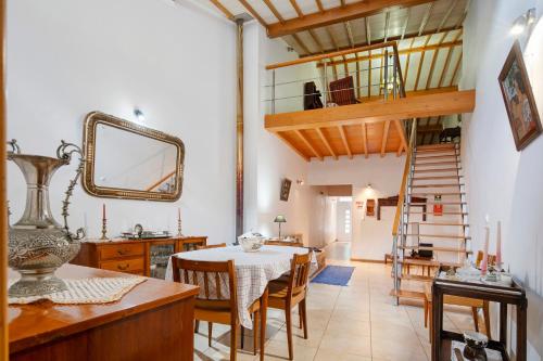 a dining room with a table and a spiral staircase at Casa Girasol in Faial da Terra